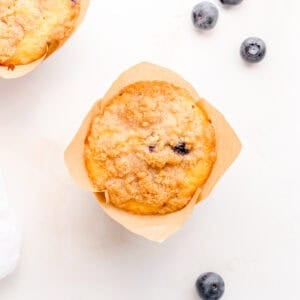 discard blueberry muffin on marble counter with blueberries.