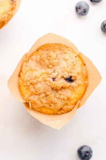 discard blueberry muffin on marble counter with blueberries.