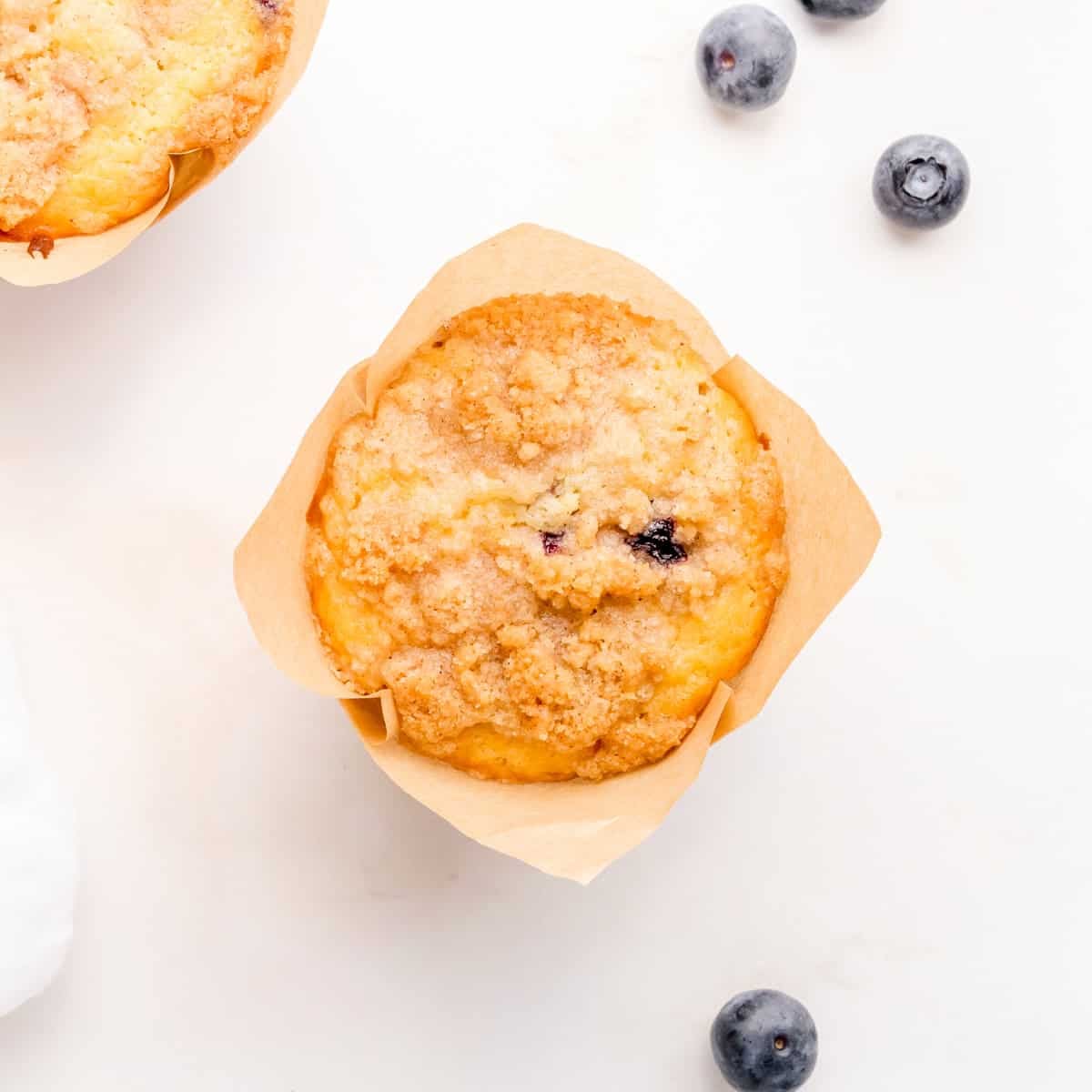 discard blueberry muffin on marble counter with blueberries.