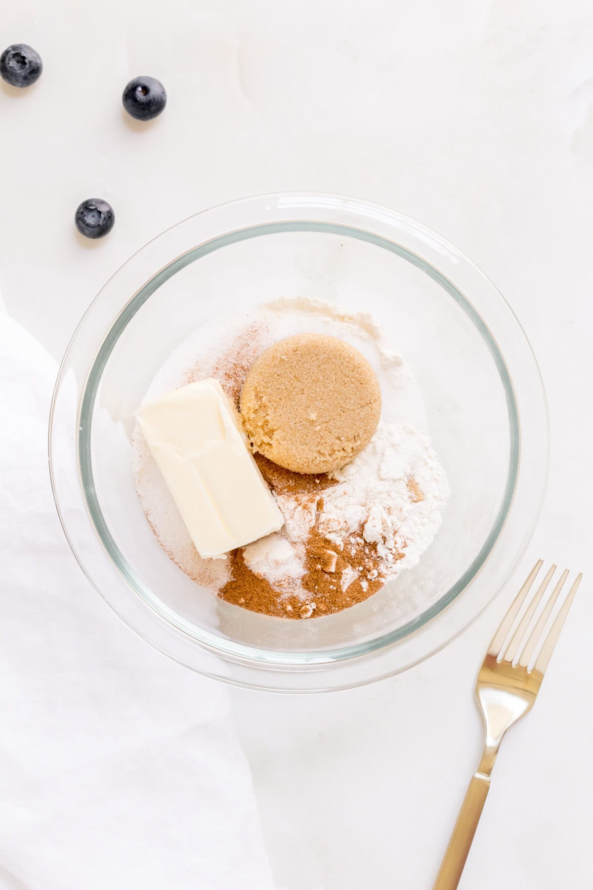 ingredients for streusel in small glass mixing bowl with gold fork.