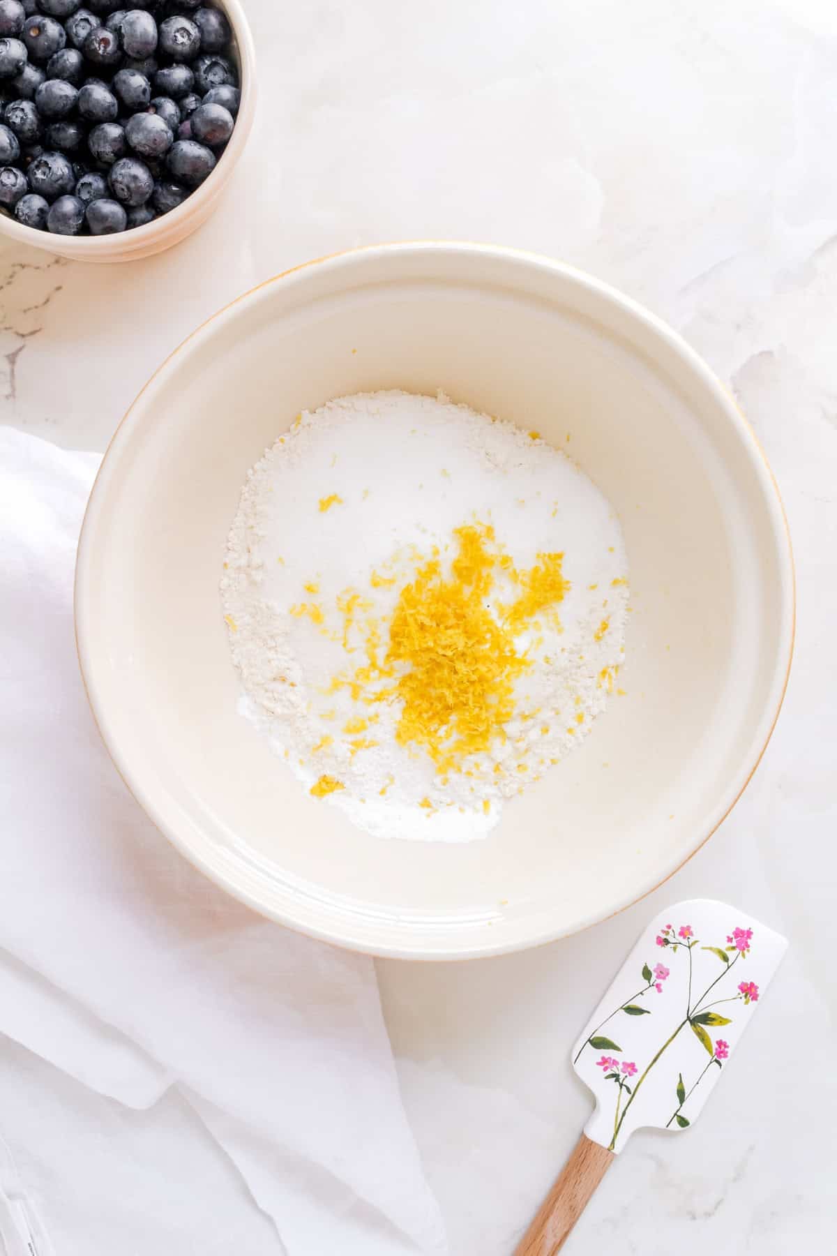 dry ingredients for discard muffins in ceramic mixing bowl with spatula.