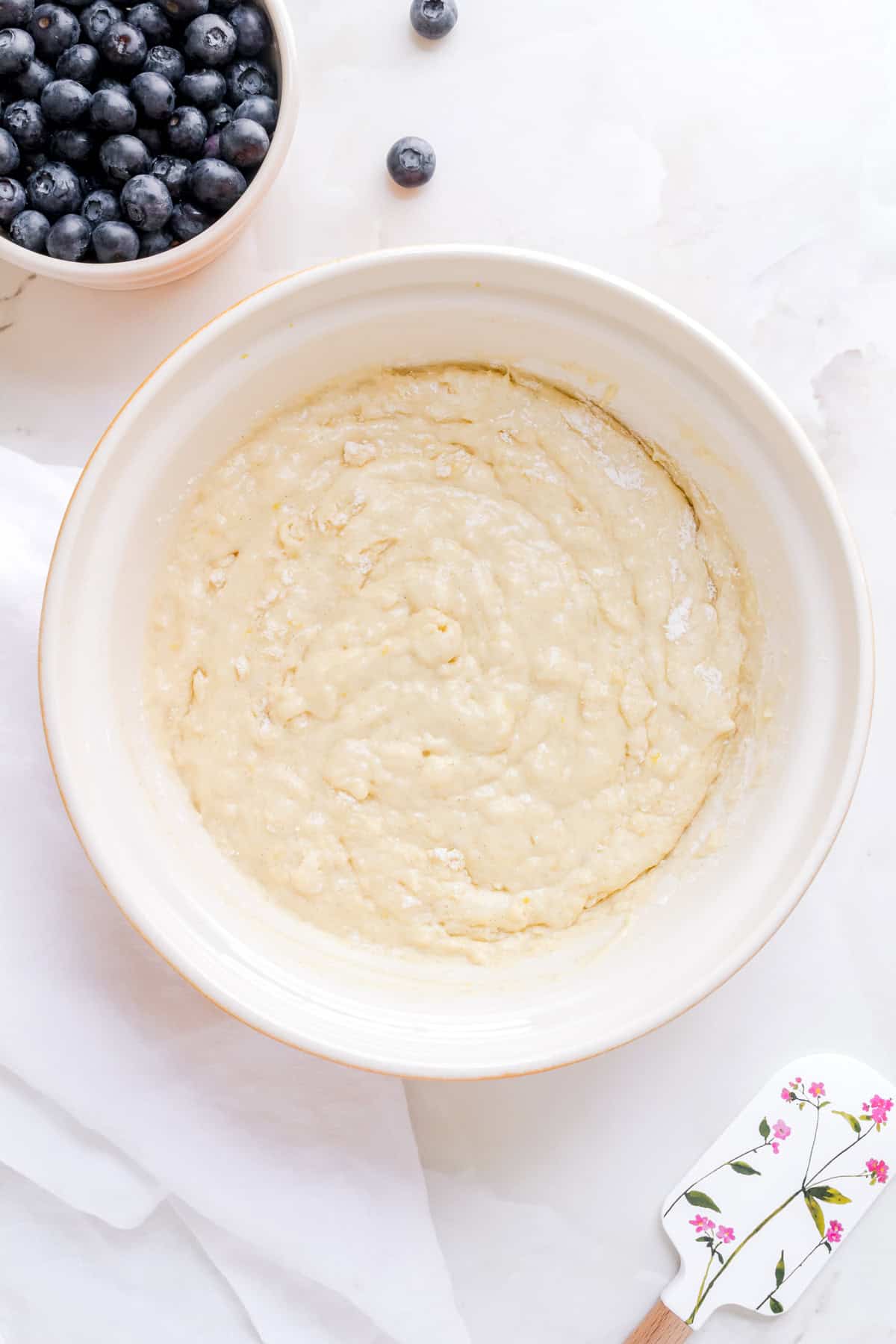 discard muffin batter in ceramic bowl with spatula.