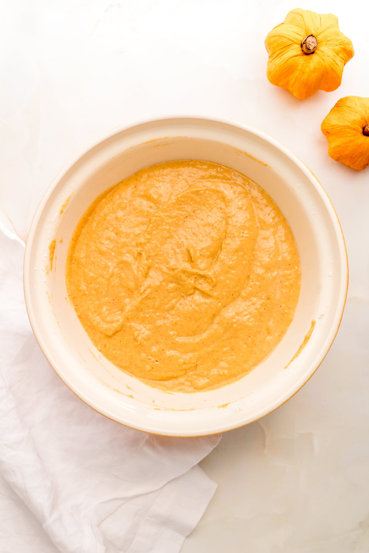 pumpkin pancake batter in a white ceramic mixing bowl.