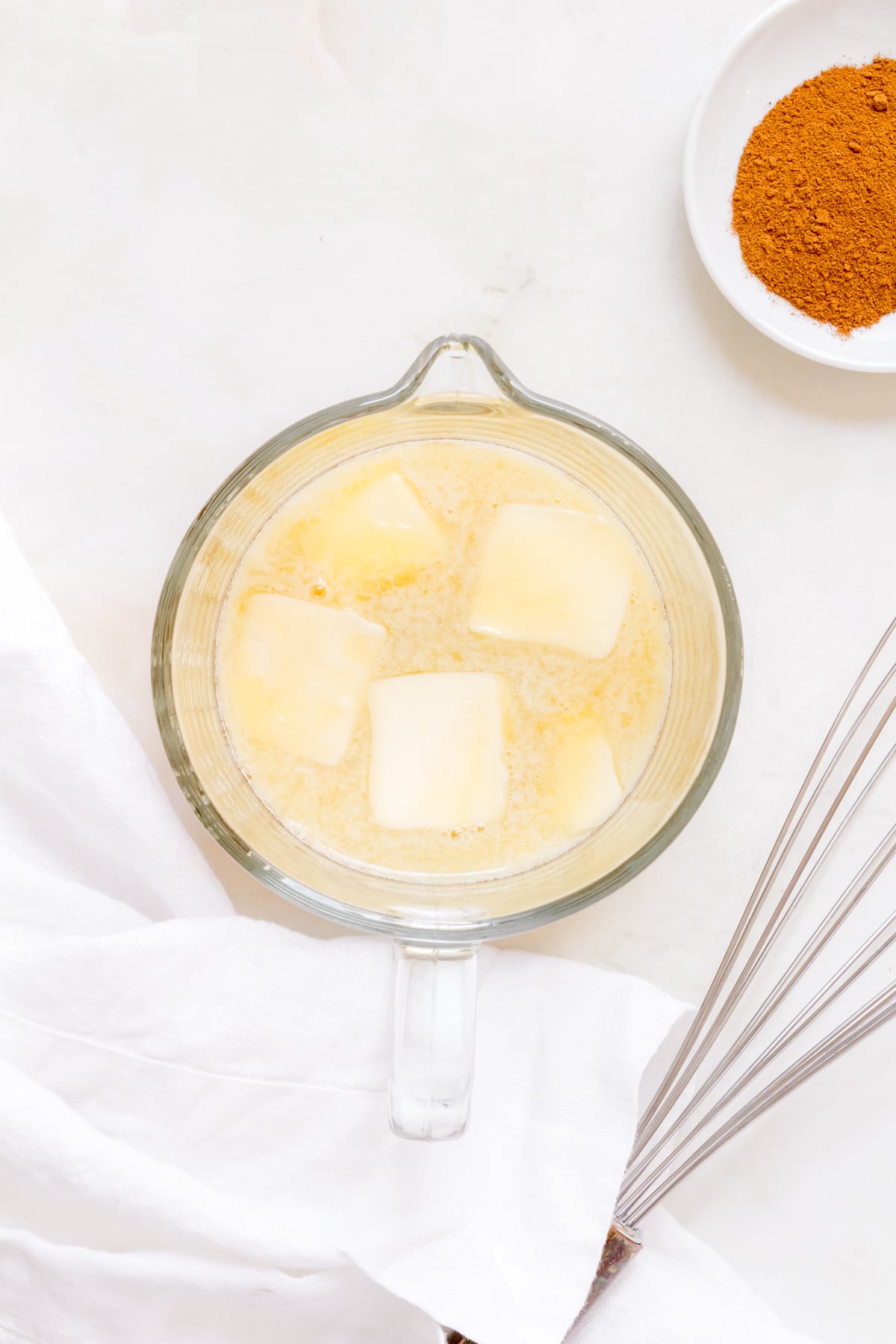 boiled apple cider and butter in a glass measuring cup.