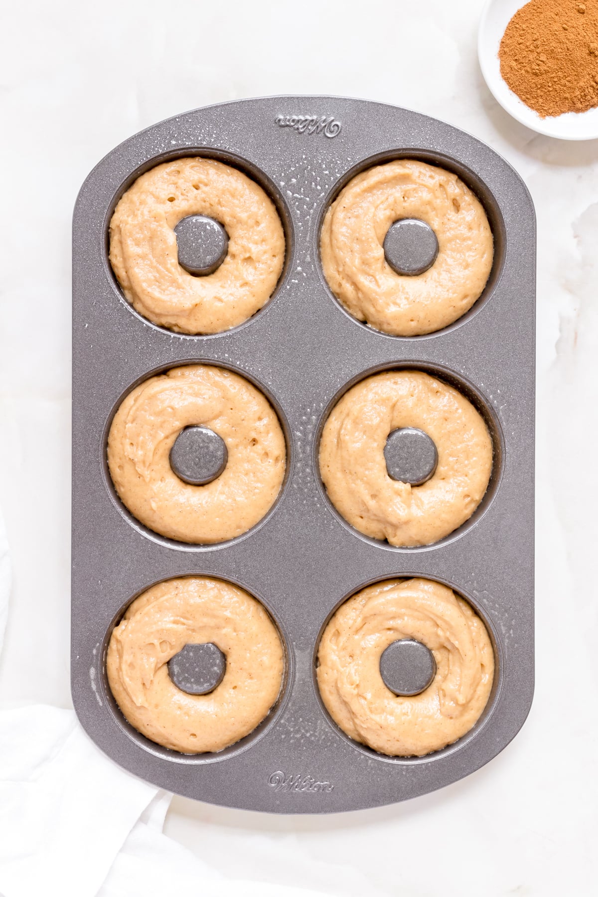 batter for apple cider donuts in baking pan.
