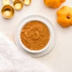 a small white bowl filled with homemade pumpkin pie spice.