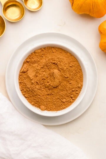 a small white bowl filled with homemade pumpkin pie spice.