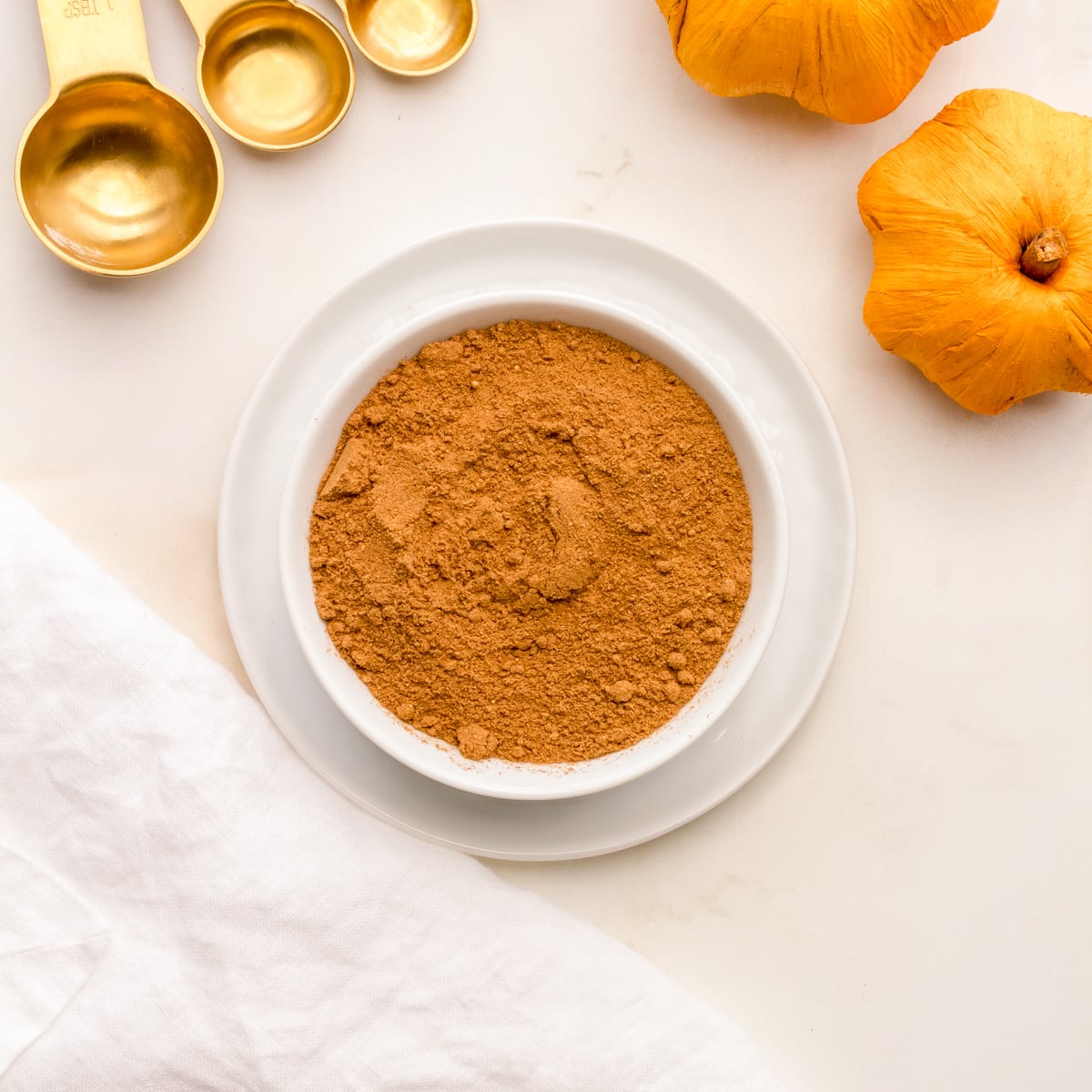 a small white bowl filled with homemade pumpkin pie spice.