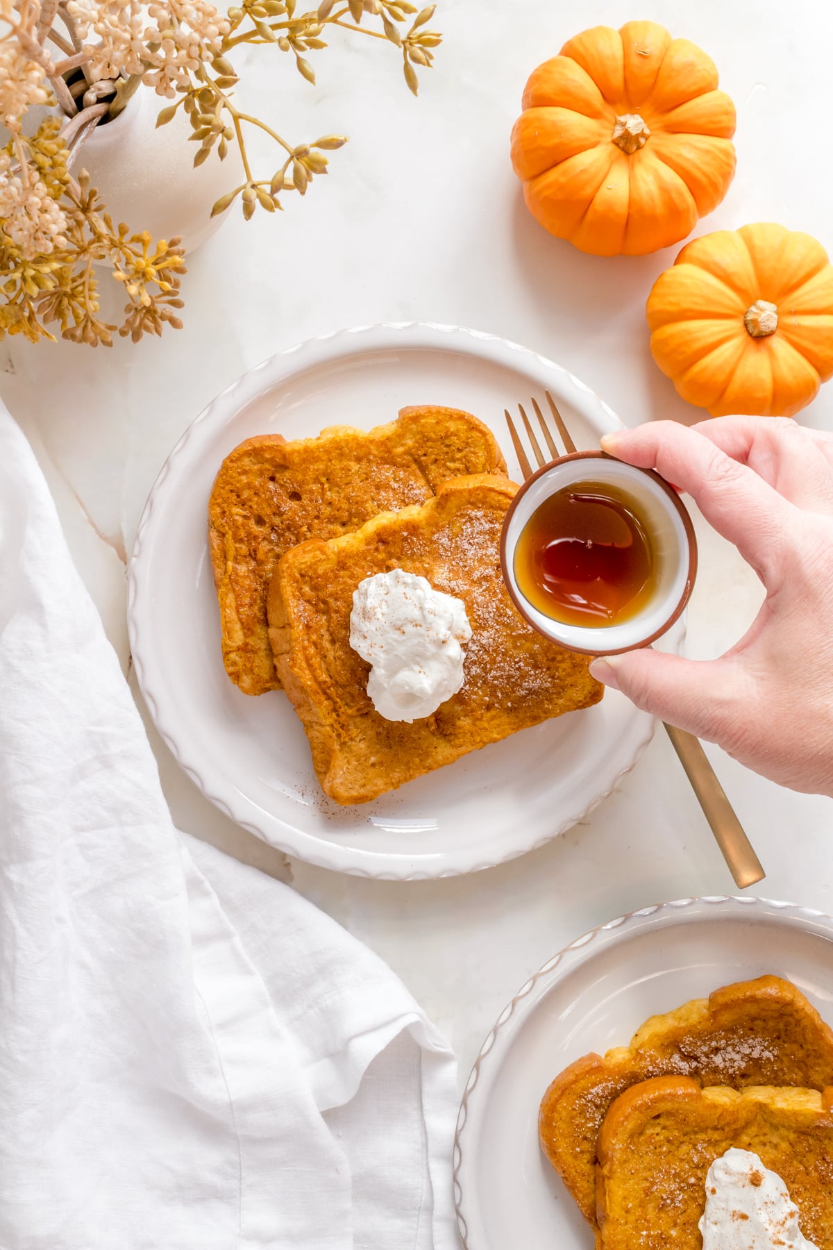 pumpkin french toast with whipped cream and maple syrup.